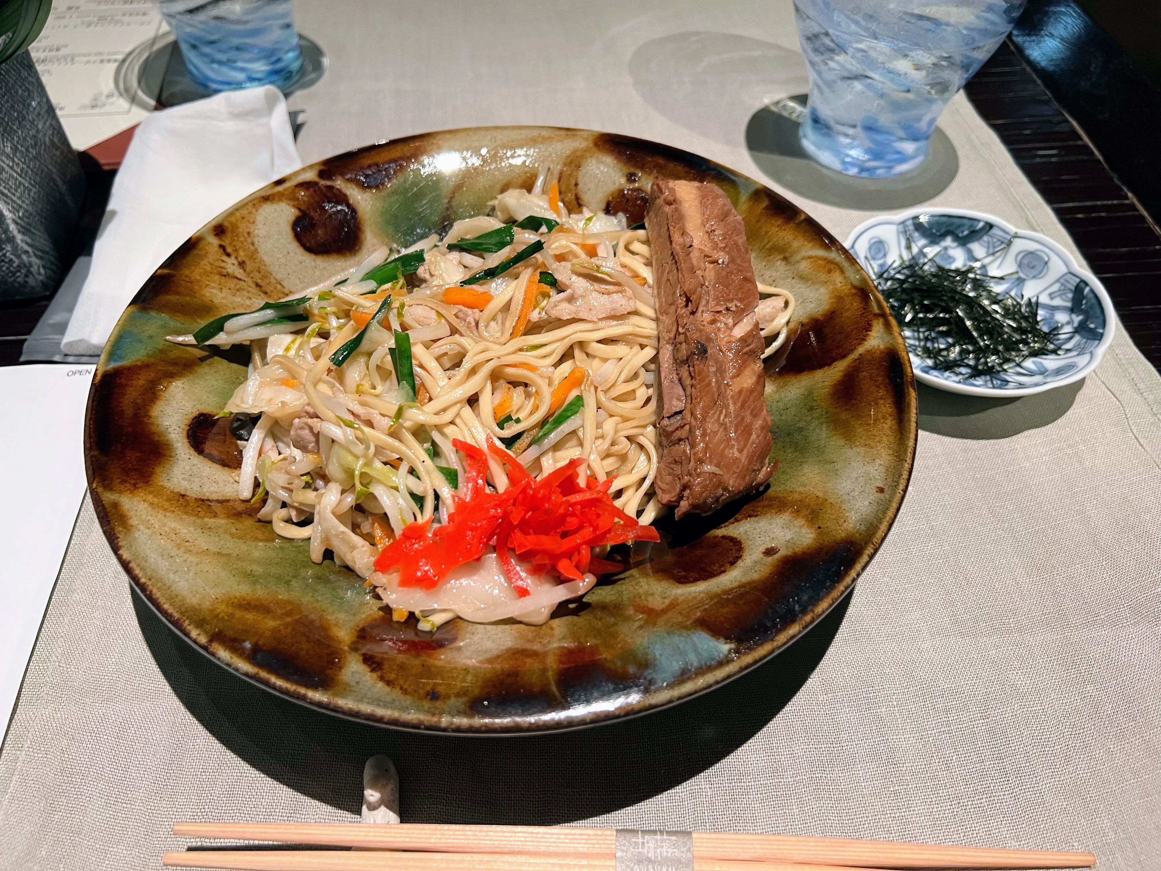 グスクの焼きそば風沖縄そば。野菜と一緒に炒められ、三枚肉が添えられている