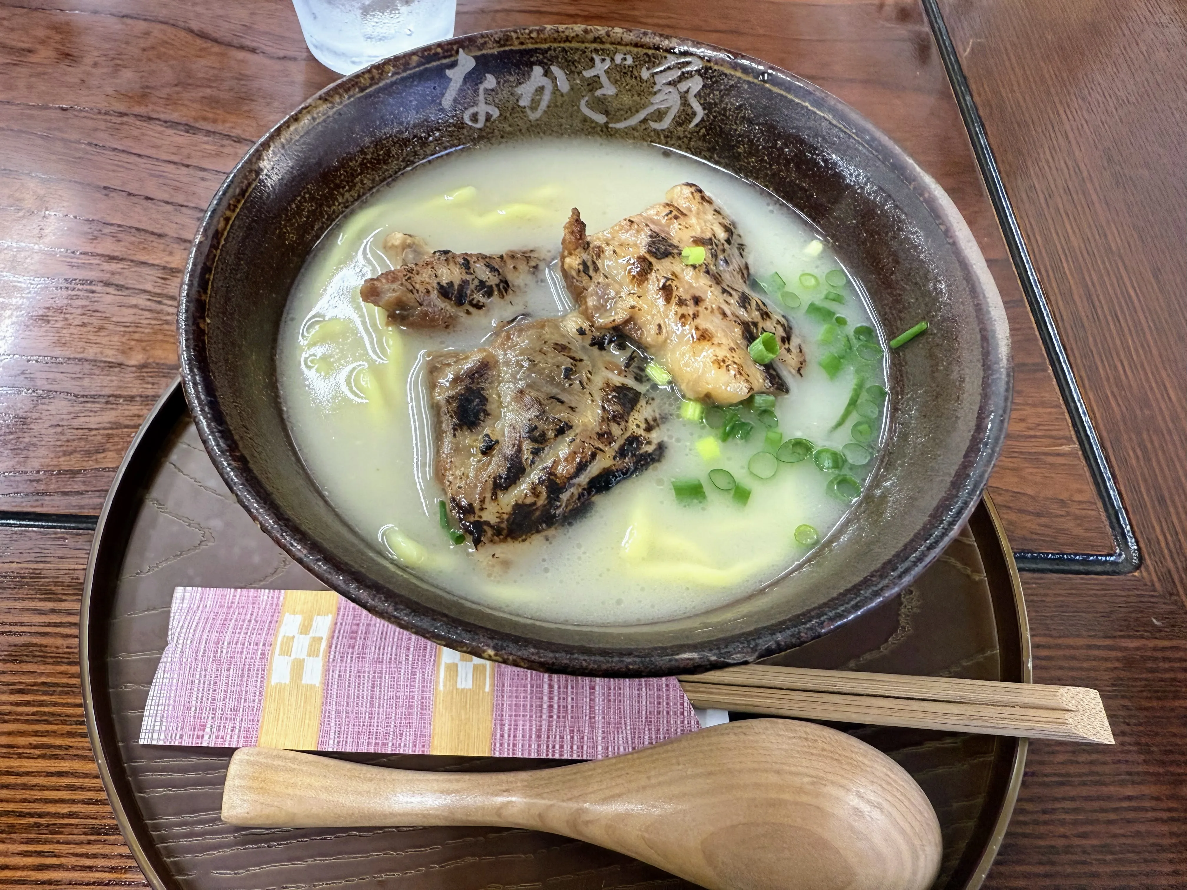 なかざ家の炙り軟骨ソーキそば。店名の焼き印が入った陶器の丼に、香ばしく炙られた軟骨ソーキがのっている